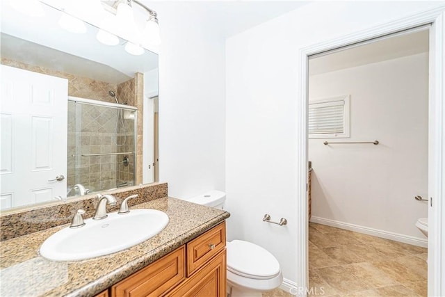 bathroom with toilet, tiled shower, and vanity