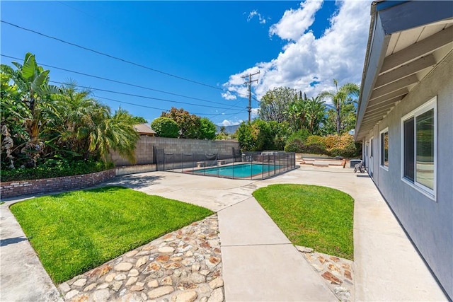 view of swimming pool with a lawn, a fenced in pool, a fenced backyard, and a patio area