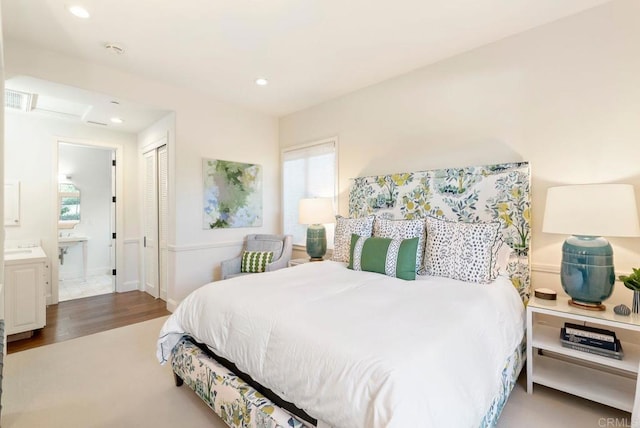 bedroom featuring recessed lighting, ensuite bathroom, wood finished floors, and a closet