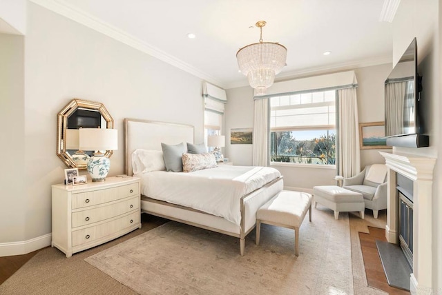 bedroom featuring a fireplace with flush hearth, baseboards, a notable chandelier, ornamental molding, and light wood-style flooring