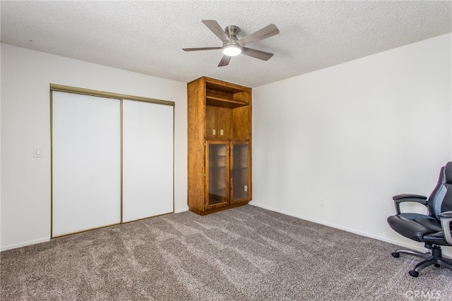 unfurnished office featuring a textured ceiling, ceiling fan, and carpet