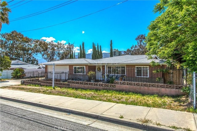 ranch-style house with a garage, a fenced front yard, and concrete driveway