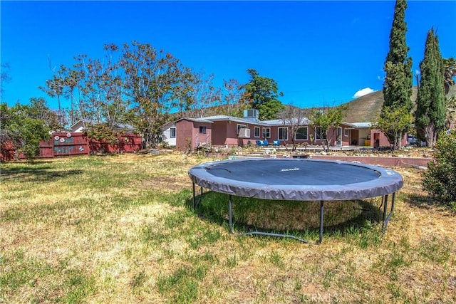 view of yard with fence and a trampoline