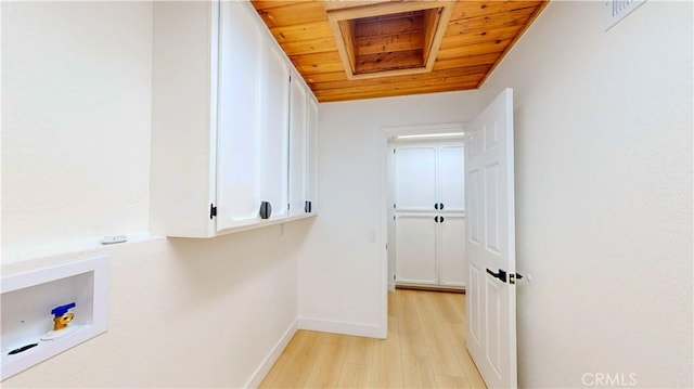 washroom featuring light wood-style floors, wood ceiling, baseboards, washer hookup, and cabinet space
