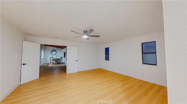 empty room with light wood finished floors, ceiling fan, and baseboards