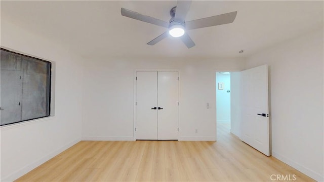 unfurnished bedroom with light wood finished floors, baseboards, a ceiling fan, and a closet