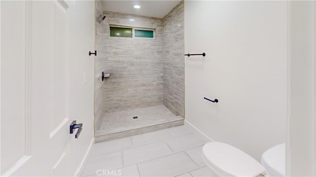full bathroom with toilet, baseboards, a tile shower, and tile patterned flooring