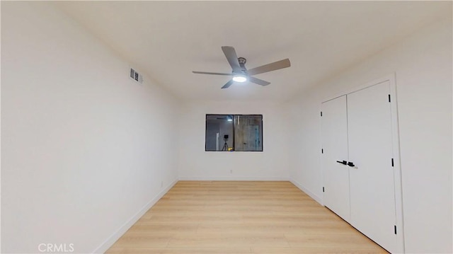 unfurnished bedroom with light wood-style floors, baseboards, a closet, and ceiling fan