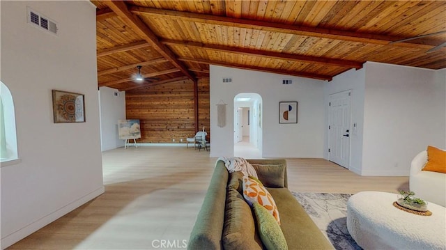 living area with arched walkways, wood ceiling, wooden walls, wood finished floors, and baseboards