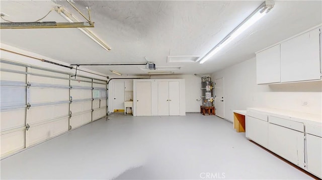 garage featuring water heater and a garage door opener