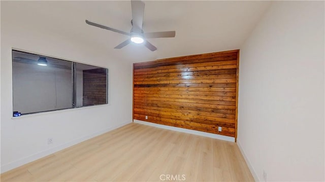 unfurnished room featuring light wood finished floors, ceiling fan, and baseboards
