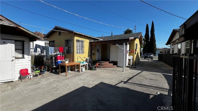 back of property featuring fence and stucco siding