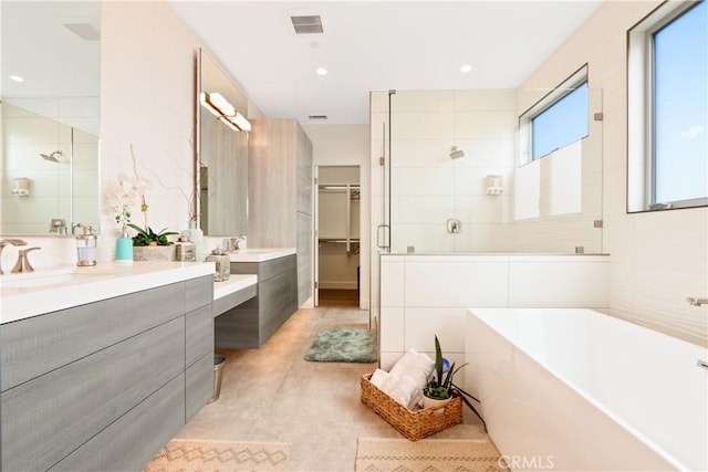 bathroom with vanity, recessed lighting, a stall shower, and a soaking tub