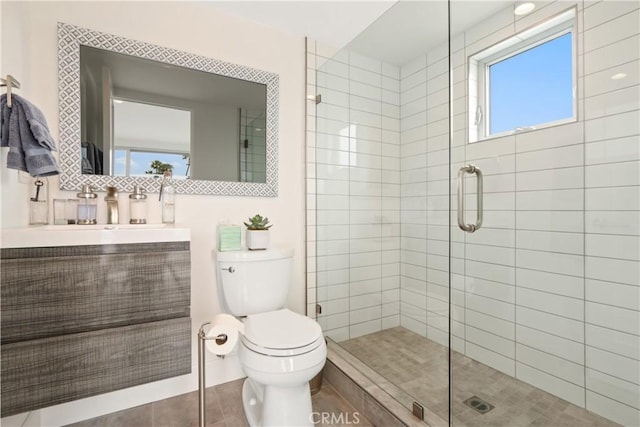 bathroom with vanity, a stall shower, and toilet