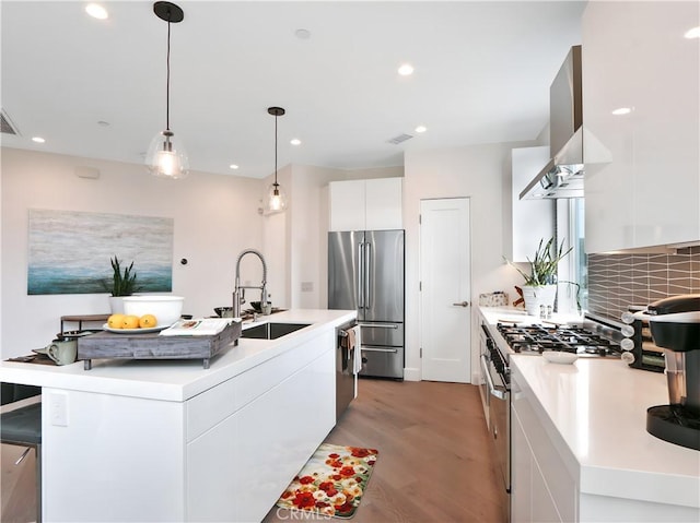 kitchen with modern cabinets, white cabinetry, a sink, stainless steel appliances, and light wood-style flooring