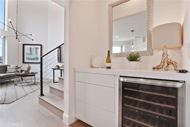 bar with stairs, wood finished floors, beverage cooler, tasteful backsplash, and a bar