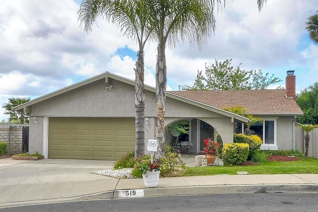 ranch-style house featuring driveway, a chimney, fence, an attached garage, and stucco siding
