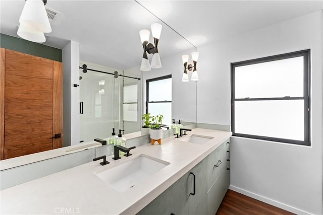 full bath with a sink, baseboards, a shower stall, and wood finished floors