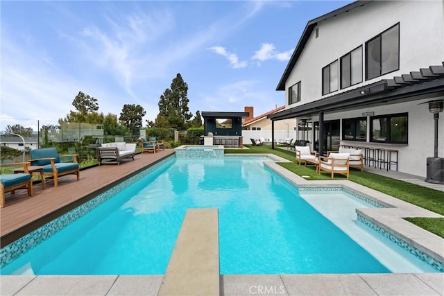 view of pool featuring a diving board, a pool with connected hot tub, outdoor dry bar, fence, and an outdoor hangout area