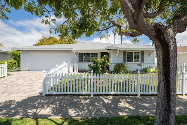 ranch-style home featuring driveway, a fenced front yard, and a garage