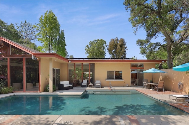back of house with a patio, an outdoor pool, and stucco siding