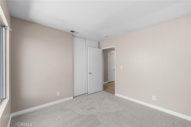 unfurnished bedroom featuring a closet, baseboards, carpet flooring, and visible vents