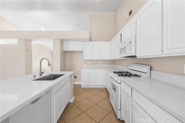 kitchen with a sink, light countertops, white appliances, and white cabinetry
