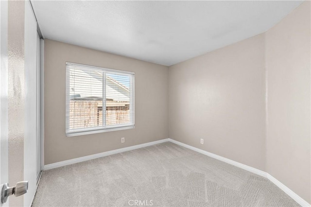 carpeted spare room with baseboards