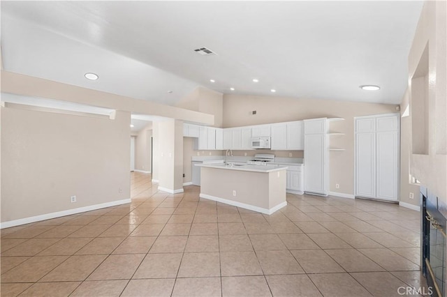 kitchen with visible vents, white microwave, white cabinetry, a sink, and range