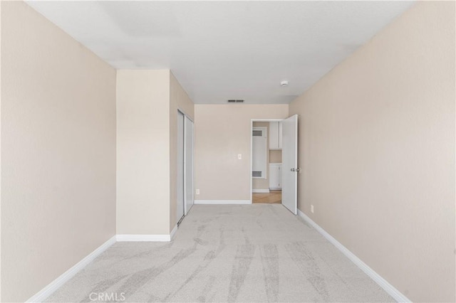 hallway with baseboards, visible vents, and carpet