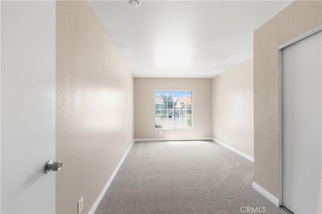 unfurnished room featuring baseboards and carpet