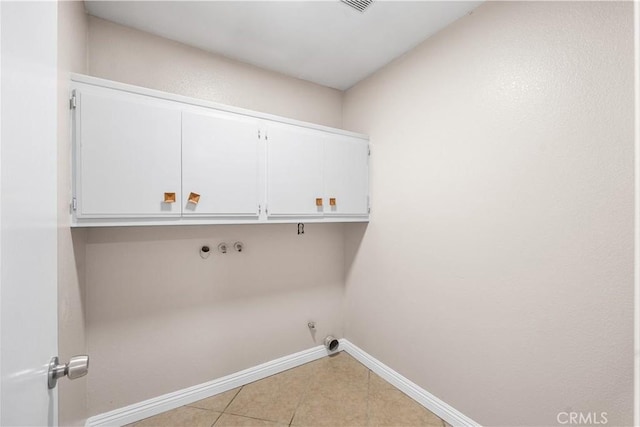clothes washing area with cabinet space, hookup for a washing machine, gas dryer hookup, baseboards, and light tile patterned floors