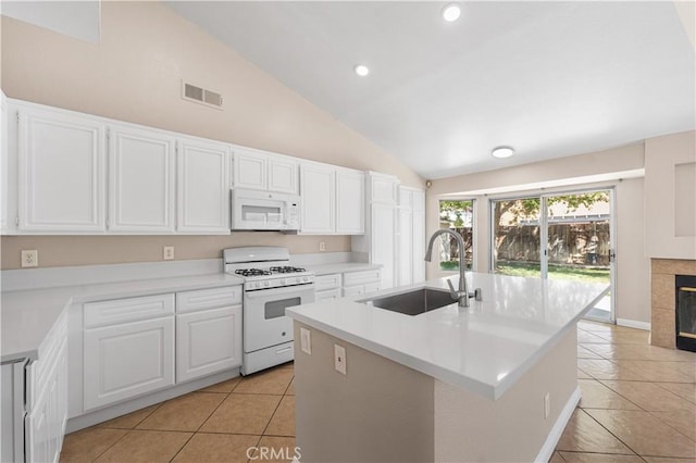 kitchen featuring white appliances, light tile patterned floors, a sink, and lofted ceiling
