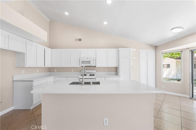 kitchen with visible vents, a sink, light tile patterned floors, lofted ceiling, and white appliances