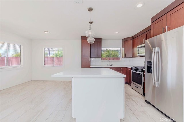 69645 Antonia Way, Rancho Mirage, CA 92270 - kitchen with stainless steel appliances, a sink, light countertops, hanging light fixtures, and tasteful backsplash