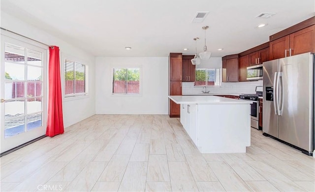 69645 Antonia Way, Rancho Mirage, CA 92270 - kitchen with stainless steel appliances, a sink, light countertops, a kitchen island, and decorative backsplash
