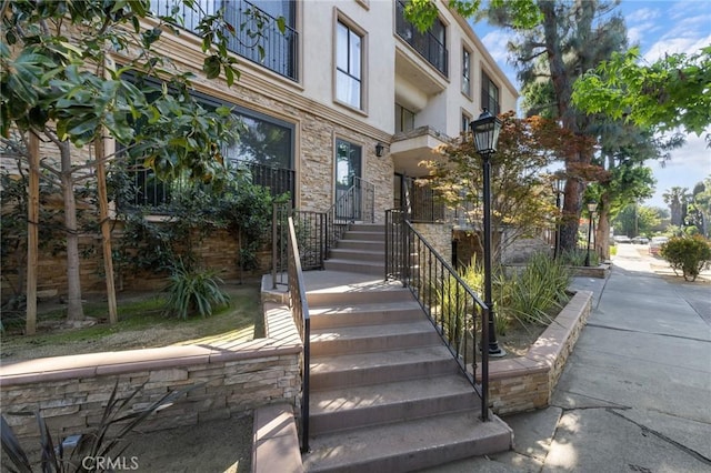 doorway to property featuring stone siding and stucco siding