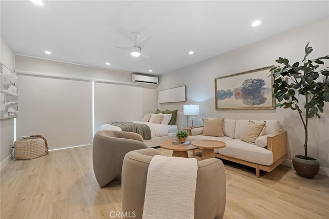 living room featuring an AC wall unit, recessed lighting, ceiling fan, and light wood-type flooring