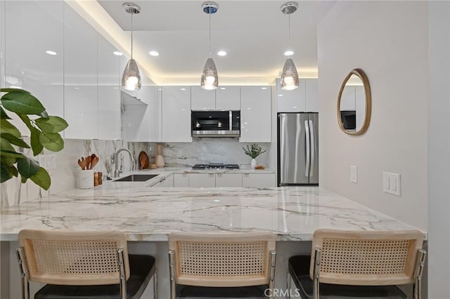 kitchen with a sink, appliances with stainless steel finishes, modern cabinets, and white cabinetry