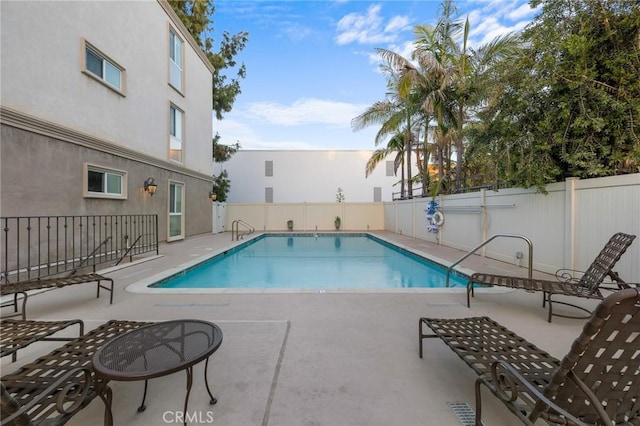 pool with fence and a patio area