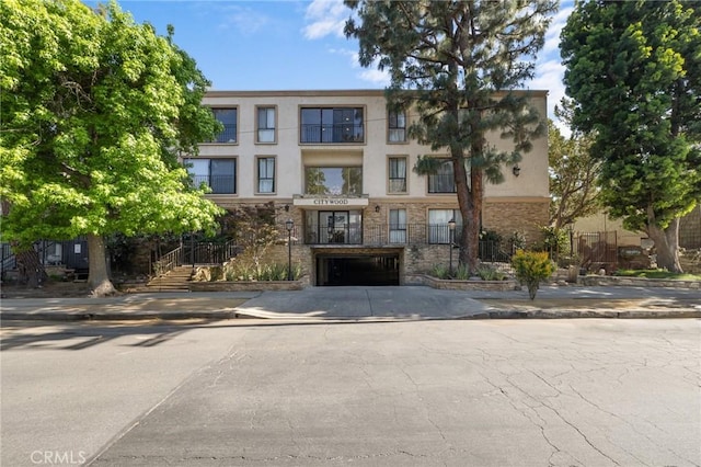 view of building exterior featuring concrete driveway and an attached garage