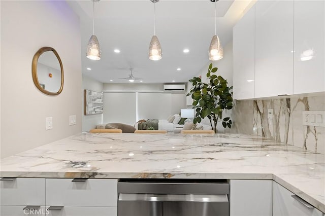 kitchen with a peninsula, a wall mounted AC, white cabinets, and light stone countertops
