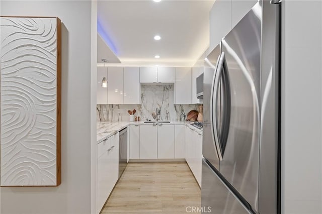 kitchen with a sink, appliances with stainless steel finishes, and modern cabinets