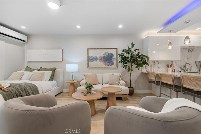 living area with recessed lighting, baseboards, light wood finished floors, and a wall mounted air conditioner