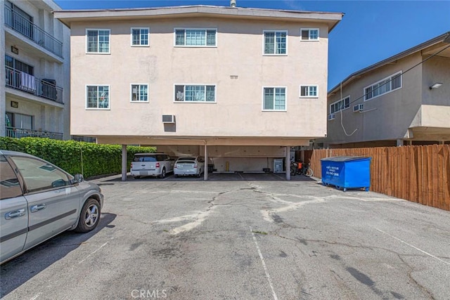 covered parking lot featuring fence