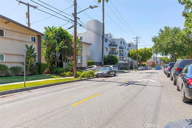 view of road with curbs, street lights, sidewalks, and a residential view