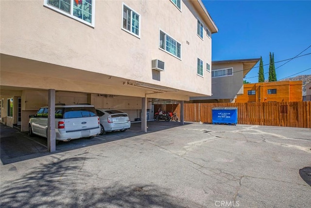 covered parking lot with fence and a wall mounted air conditioner