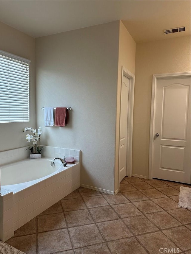 bathroom with baseboards, tile patterned flooring, a bath, and visible vents