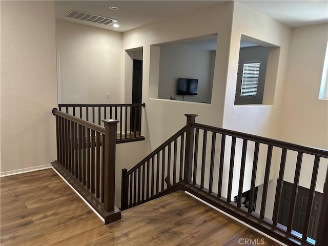 staircase featuring baseboards, recessed lighting, wood finished floors, and visible vents