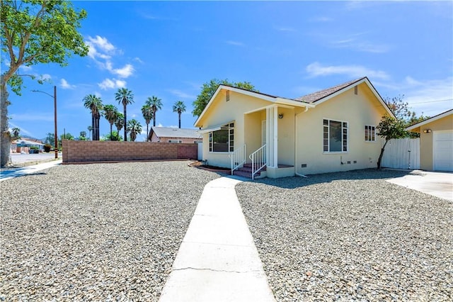 ranch-style house featuring stucco siding and fence